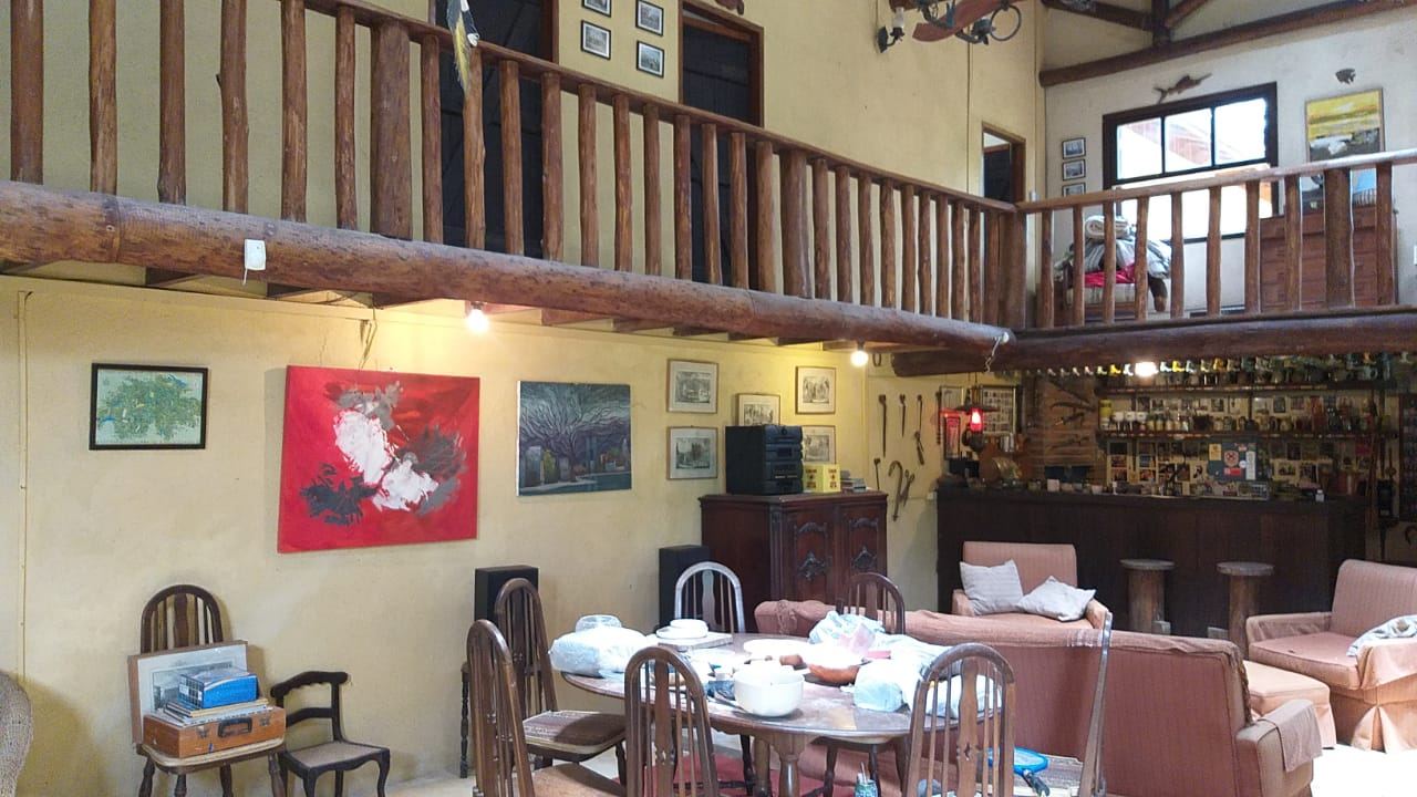 Interior do salão, com mezanino de madeira, mesas postas e decoração nas paredes